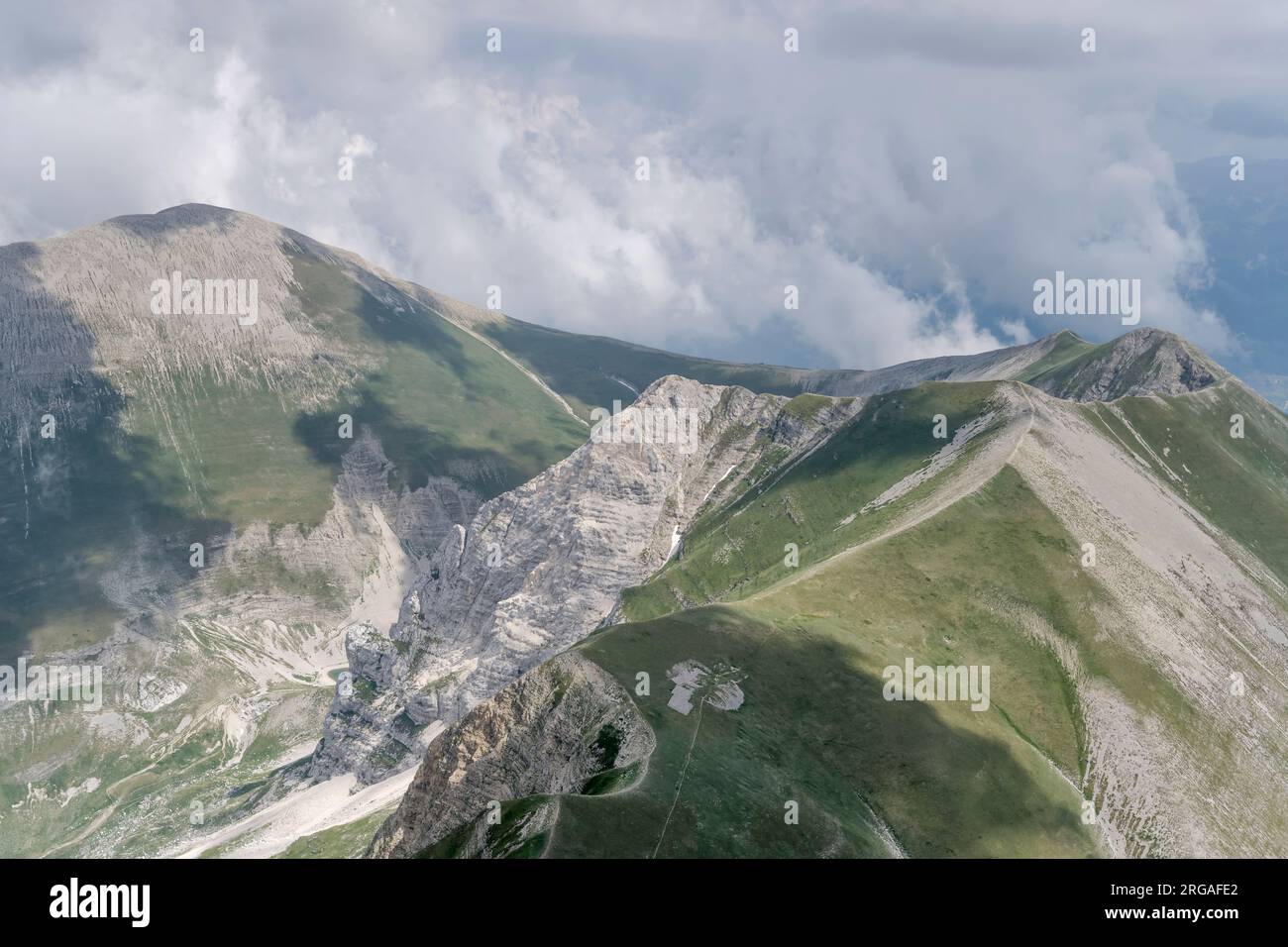 Luftlandschaft, von einem Segelflugzeug, mit steilen Klippen am Vettore Peal Summit und Meeresbrise Wolken, die von Norden in hellem Sommerlicht nahe No gedreht werden Stockfoto