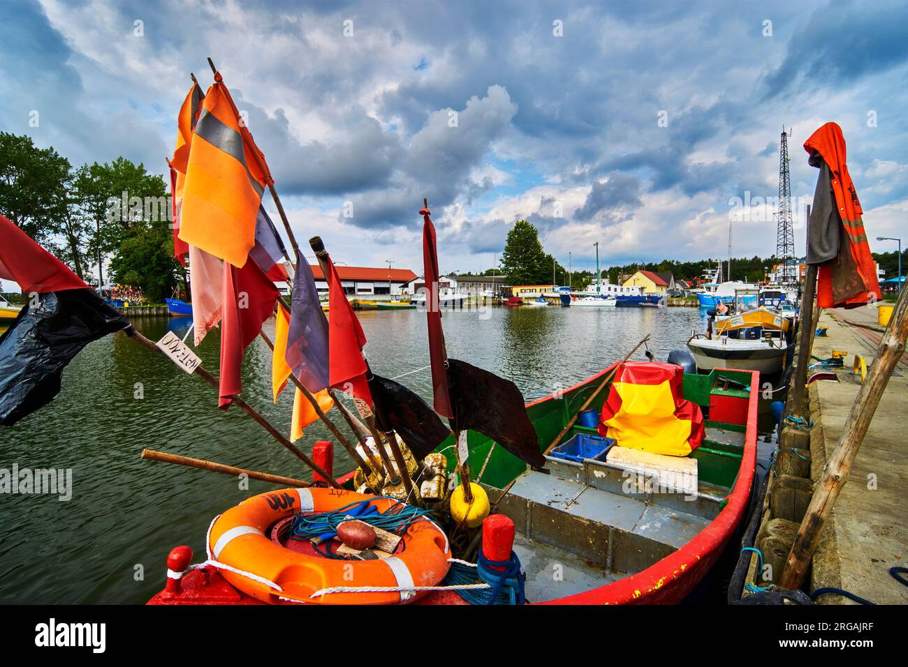 Fischerboot mit Fangflaggen im Hafen von Rybacka an der Curonischen Lagune in Polen Stockfoto