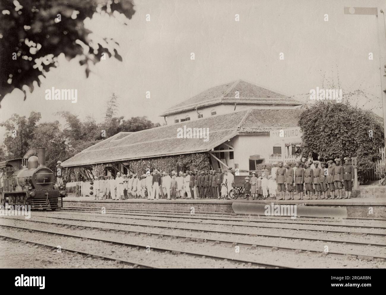 19. Jahrhundert Vintage-Fotografie - große Gruppe von Indern und Europäern an einem Bahnhof mit Dampfmaschine, Indien, um 1880. Stockfoto