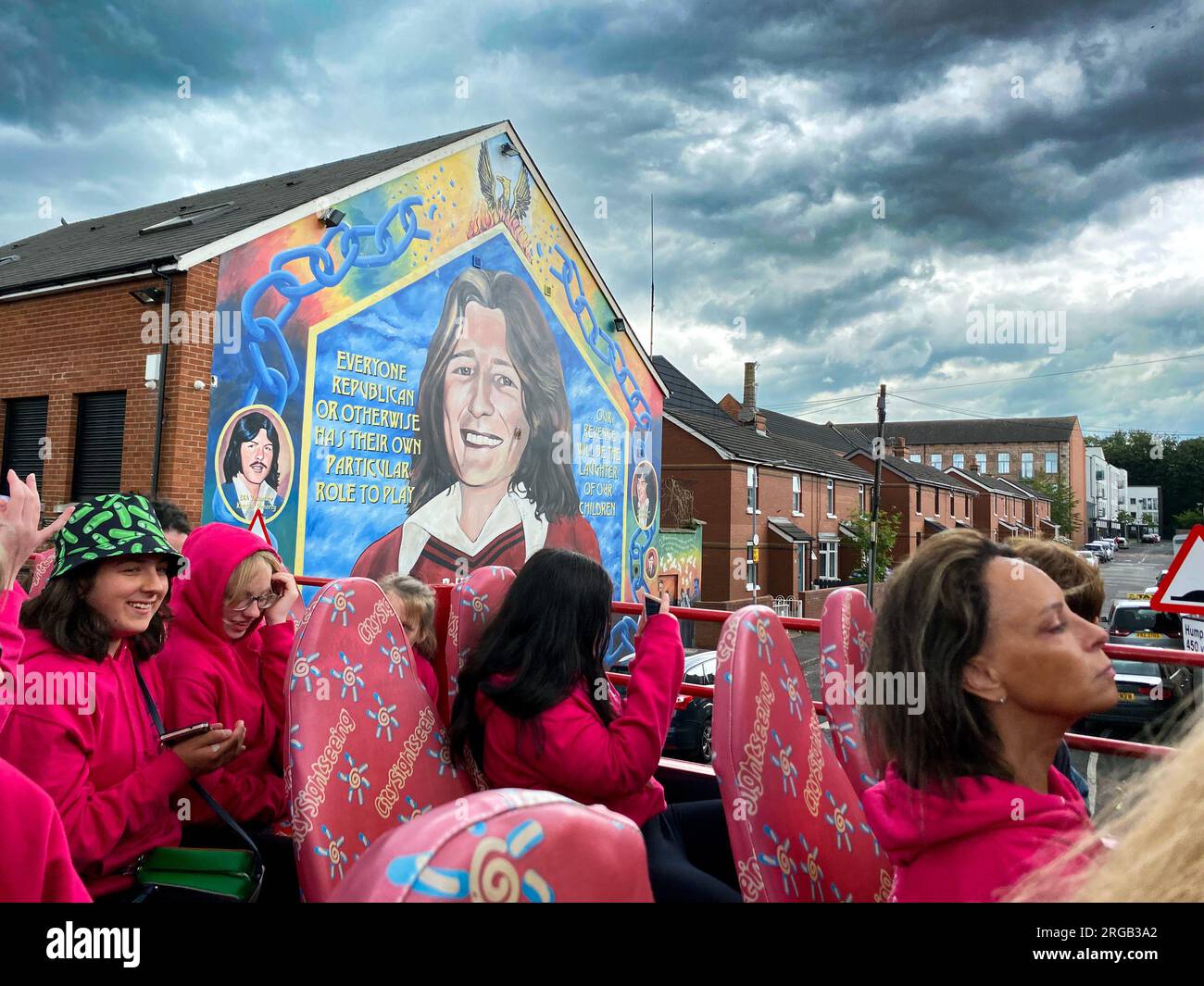 Leute im Tourbus in Belfast, Nordirland, halten an, um sich das Bobby Sands Wandbild in Belfast anzusehen Stockfoto