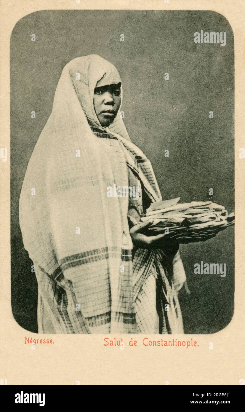 Afrikanische Straßenverkäuferin in Istanbul, Türkei mit einem Korb Brot. Stockfoto