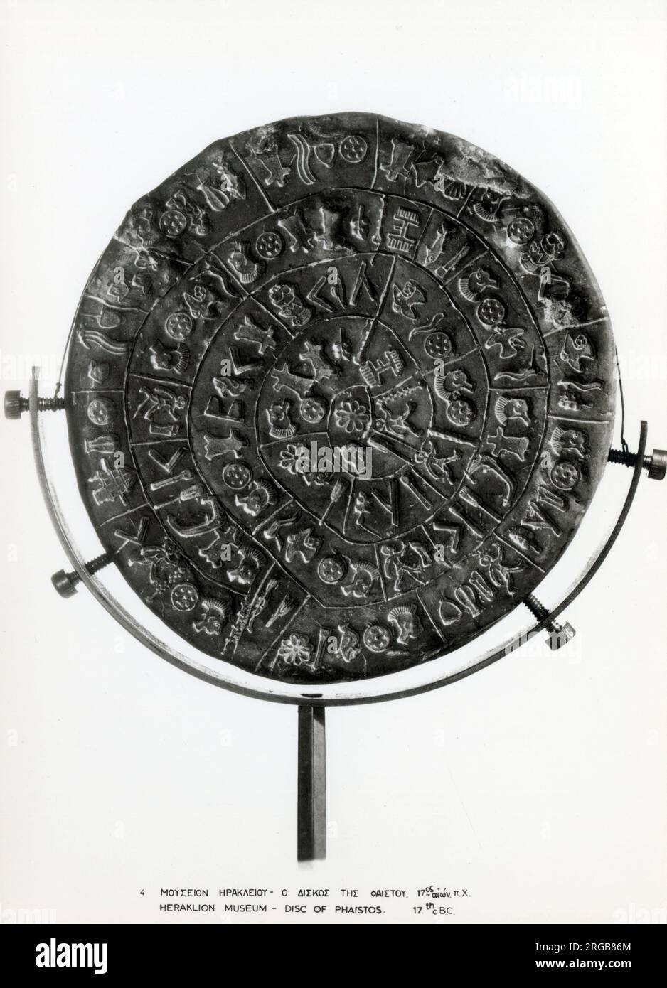 Die Phaistos Disc (auch Phaistos Disk genannt, Phaestos Disc) ist eine Scheibe aus gebranntem Ton aus dem minoischen Palast von Phaistos auf der Insel Kreta, möglicherweise aus der mittleren oder späten minoischen Bronzezeit (zweites Jahrtausend v. Chr.). Die Scheibe hat einen Durchmesser von ca. 15 cm (5,9 Zoll) und ist auf beiden Seiten mit einer Spirale von gestanzten Symbolen bedeckt. Die Phaistos Disc wurde im minoischen Palast von Phaistos in der Nähe der Hagia Triada an der Südküste Kretas entdeckt. Stockfoto