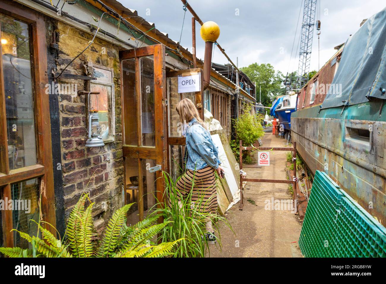 Frau, die in ein Künstlerstudio in der Künstlergemeinde von Eel Pie Island in Twickenham, London, UK geht Stockfoto