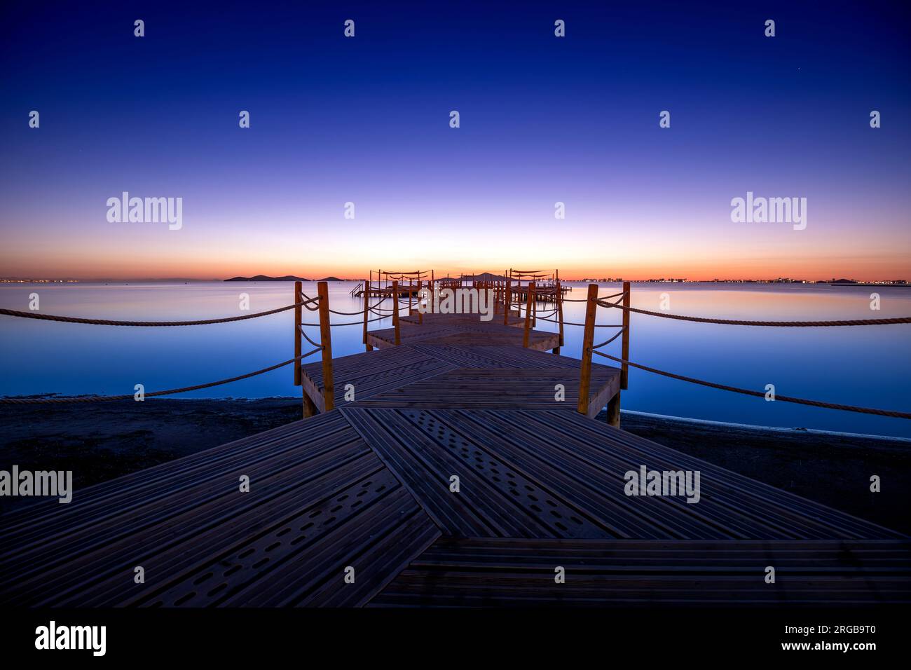 Holzsteg am Strand von Punta Brava bei einem warmen Sonnenaufgang in Cartagena, Region Murcia, Spanien Stockfoto