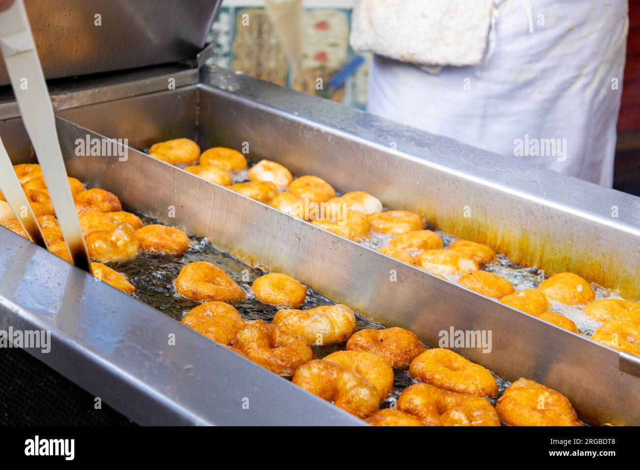 Ich koche valencianische Donuts. Braten traditioneller spanischer süßer Speisen, genannt Rocilla oder Rockos. Stockfoto