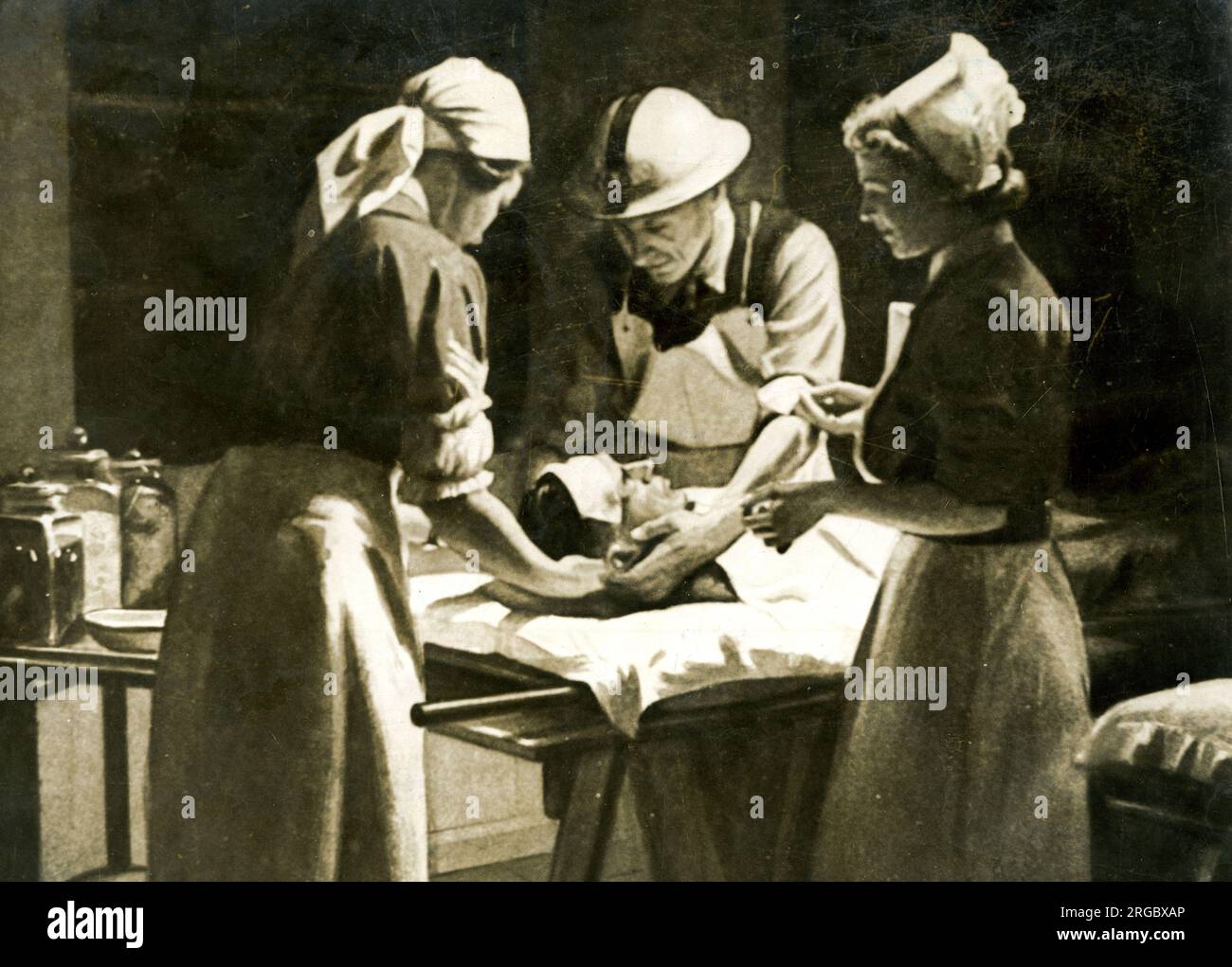 Heim Krankenschwestern und Arzt operieren bei Verletzten, WW2 Stockfoto