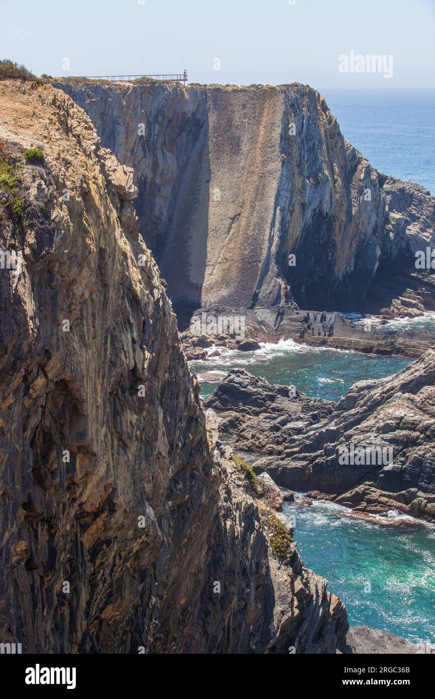 Besucher, die das Meer vom Pfad aus in der Nähe der Klippen der Küste von Cabo Sardao, Ponta do Cavaleiro, Sao Teotonio, Portugal beobachten Stockfoto