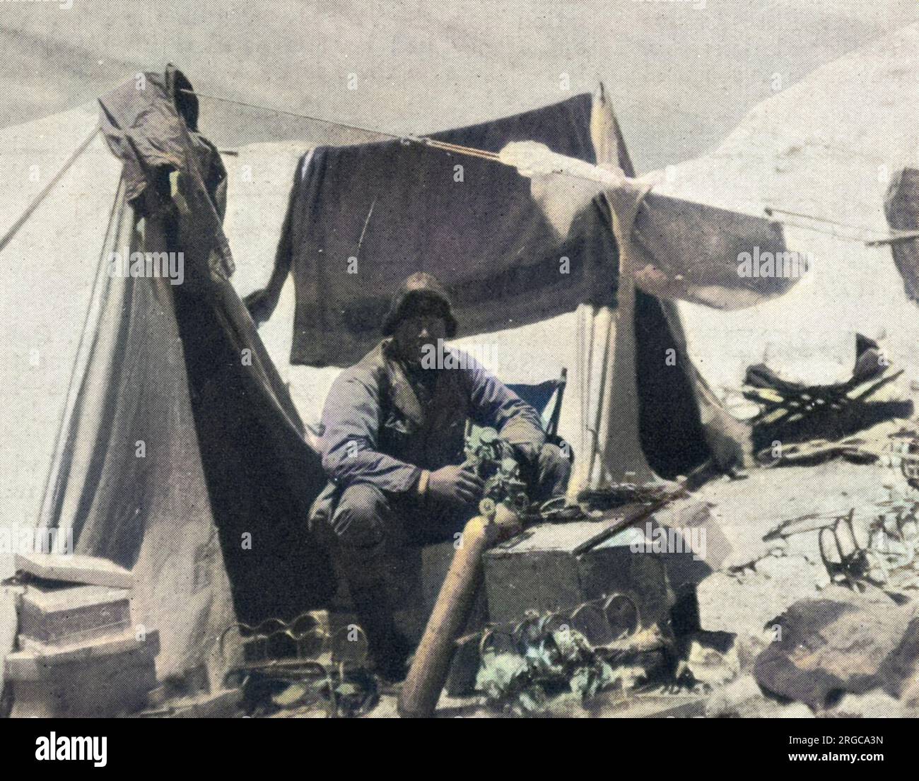 Foto von Andrew Comyn Irvine (1902-24), dem britischen Bergsteiger, der im Everest Expeditionslager 1924 an einer Sauerstoffflasche arbeitete. Irvine, obwohl ein relativ unerfahrener Kletterer, war ein Experte in der Wartung und Reparatur von Sauerstofftanks, und wegen dieser Fähigkeit wurde er ausgewählt, George Leigh Mallory für ihren tödlichen Anschlag auf den Everest zu begleiten. Stockfoto