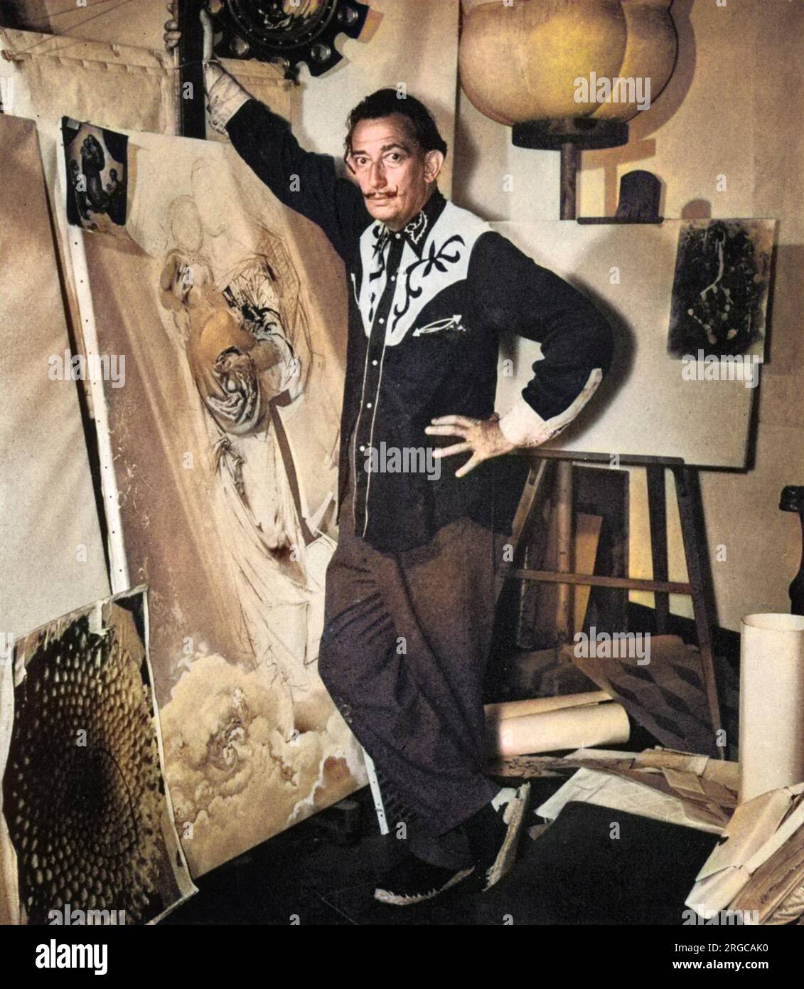 Salvador Dali (1904 - 1989), hier mit einer vergrößerten Fotografie eines Seeigels fotografiert, was auf ein surrealistisches Muster hindeutet - im linken Vordergrund. Die Gipsform am oberen Rand des Hintergrunds ist ein Modell eines Atoms. Stockfoto