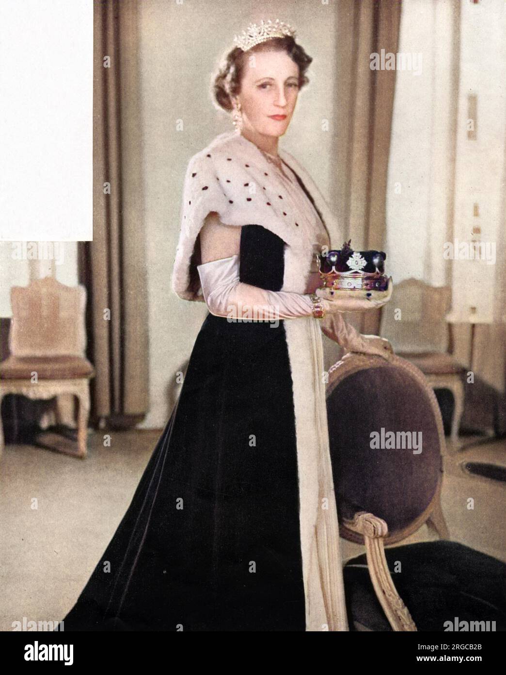 Lady Delamere (1906 - 1979), ehemals Ruth Mary Clarisse Ashley (Schwester von Edwina Ashley, Gräfin Mountbatten), trägt einen der neuen Bademäntel für Peeressen, entworfen von Norman Hartnell zur Krönung von Königin Elizabeth II. Im Jahr 1953. Darunter ist ihr Kleid, ebenfalls von Hartnell, aus weißem marocain mit Goldperlen bestickt. Stockfoto