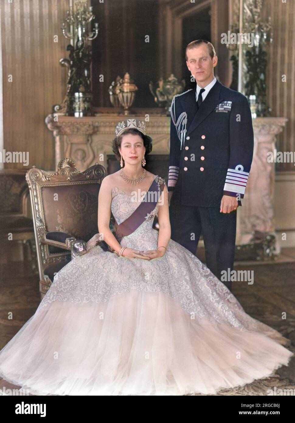 Königin Elizabeth II. Und Prinz Philip, Herzog von Edinburgh, wurden 1954 zusammen am Grand Entrance im Buckingham Palace fotografiert. Die Königin trägt ein gelbes Abendkleid aus Tülle, dekoriert mit Mimosaspray und goldenen Pailette-Stickereien und trägt das blaue Band und den Star des Strumpfes. Ihre Halskette war ein Hochzeitsgeschenk von Nizam von Hyderabad; das Diadem war auch ein Hochzeitsgeschenk von Königin Mary. Die Schleifenbrosche und die Ohrhänger sind mit Diamanten versehen. Der Herzog trägt die Uniform des Admirals der Flotte. Stockfoto