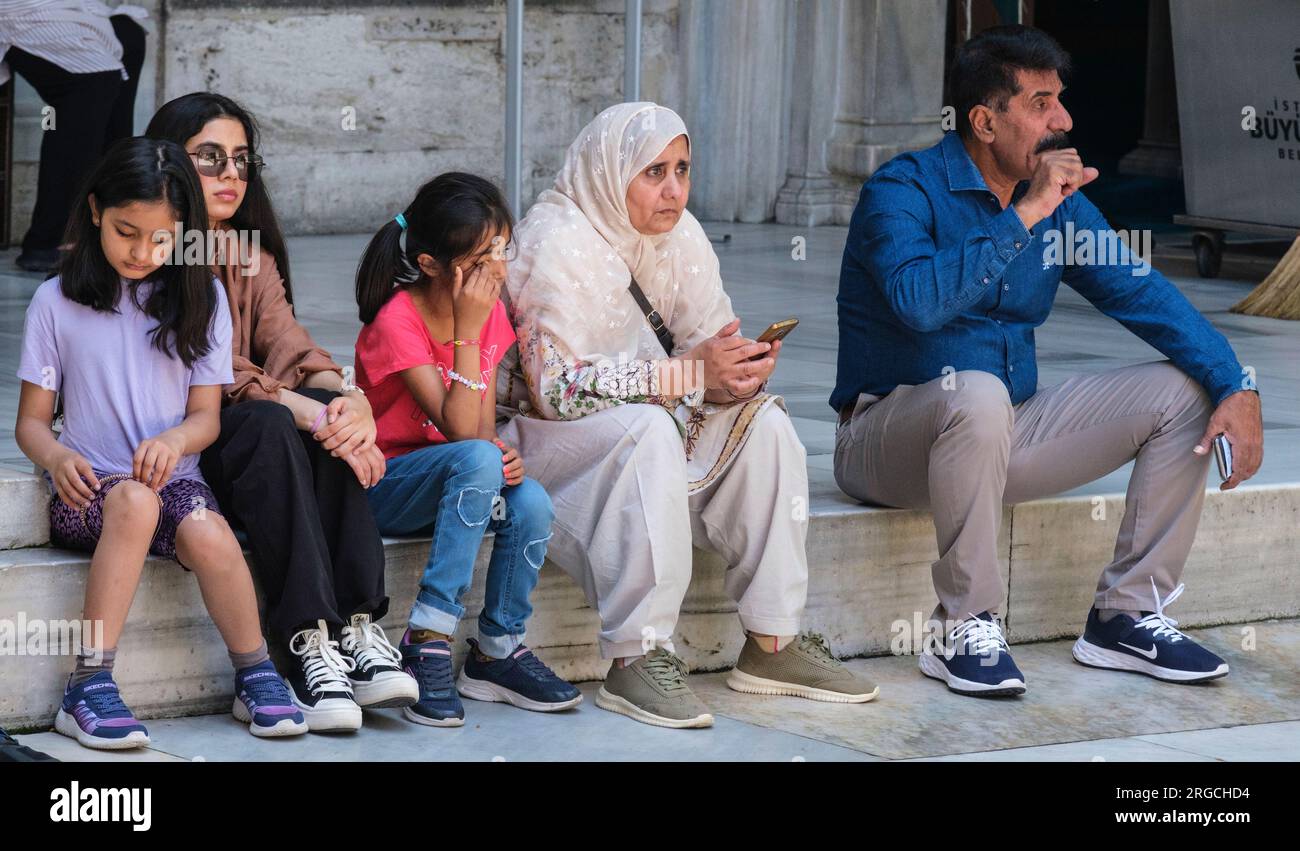 Istanbul, Türkei, Turkiye. Eyup Sultan Moschee, Familie wartet vor dem Hauptgebetssaal. Stockfoto