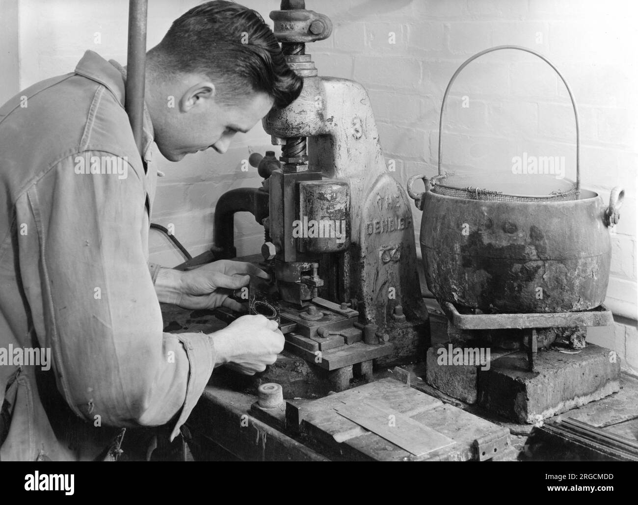Fabrikarbeiter, der eine Handpresse bedient. Stockfoto