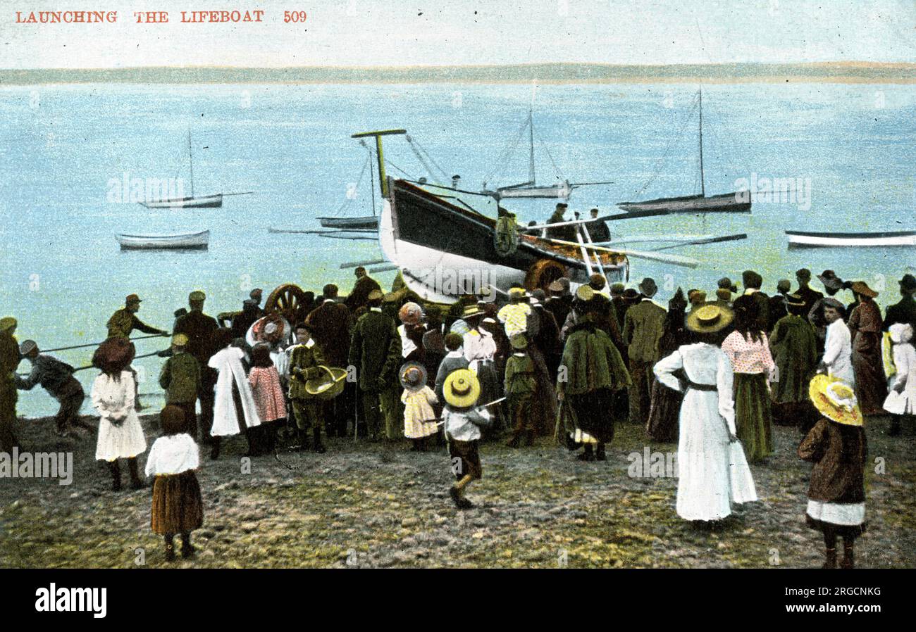 Das Rettungsboot starten - Leute beobachten vom Strand aus Stockfoto
