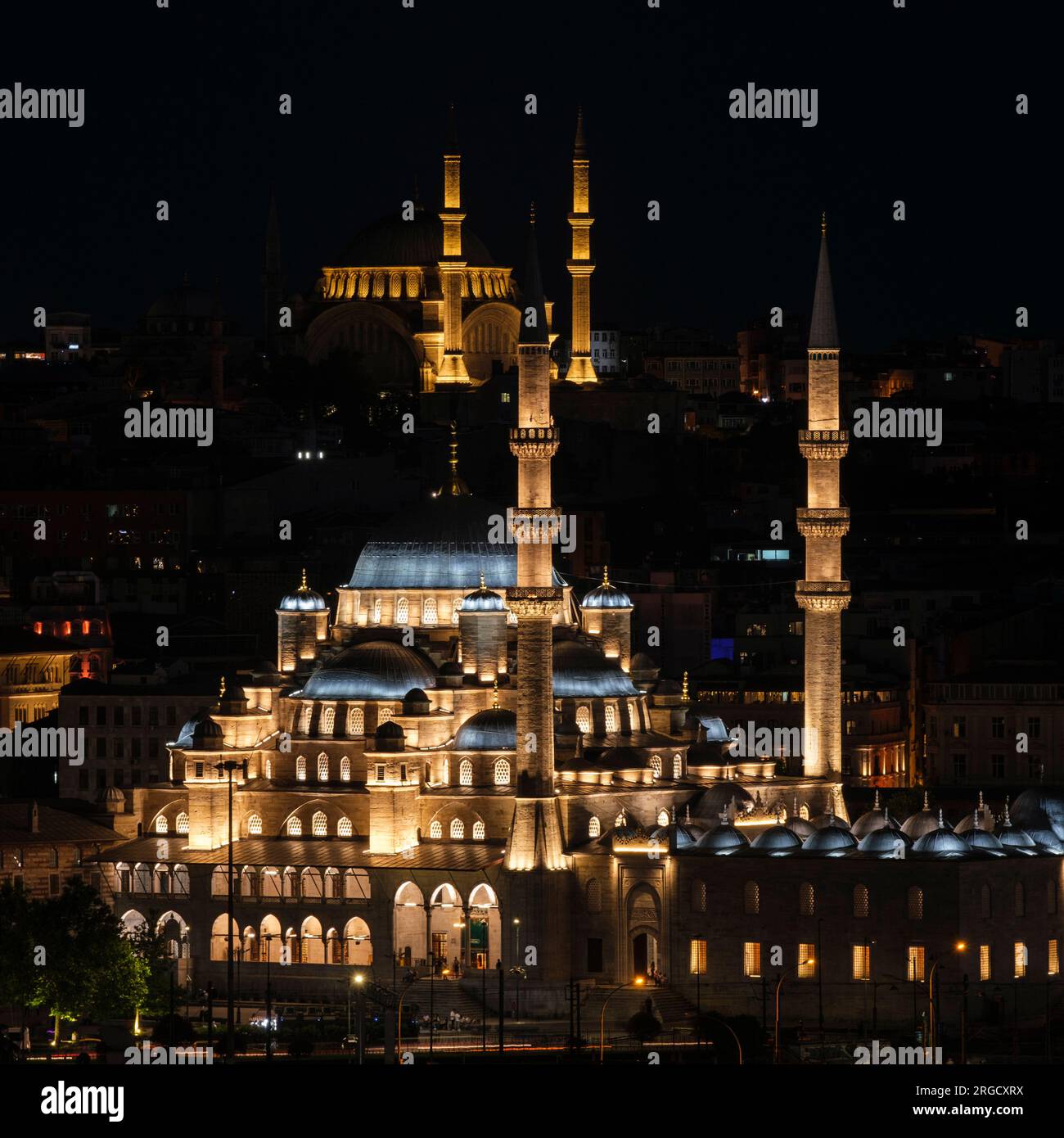 Istanbul, Türkei, Türkiye. Neue Moschee (Yeni Camii) bei Nacht. Blaue Moschee auf einem Hügel im Hintergrund. Stockfoto