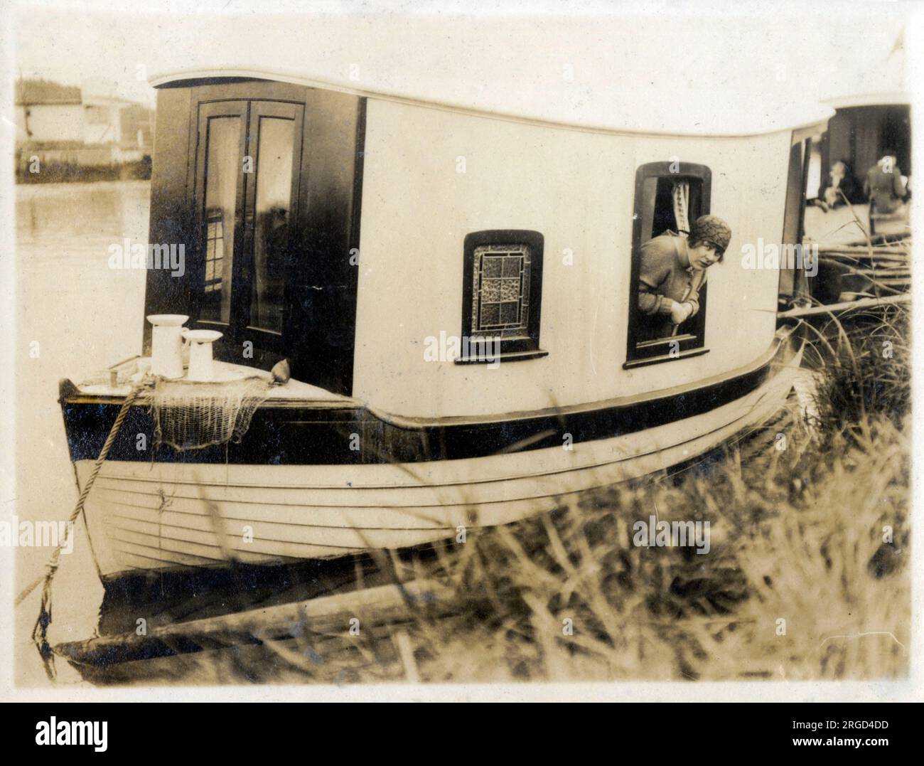 Hübsches Miniatur-Hausboot und Insasse. Stockfoto