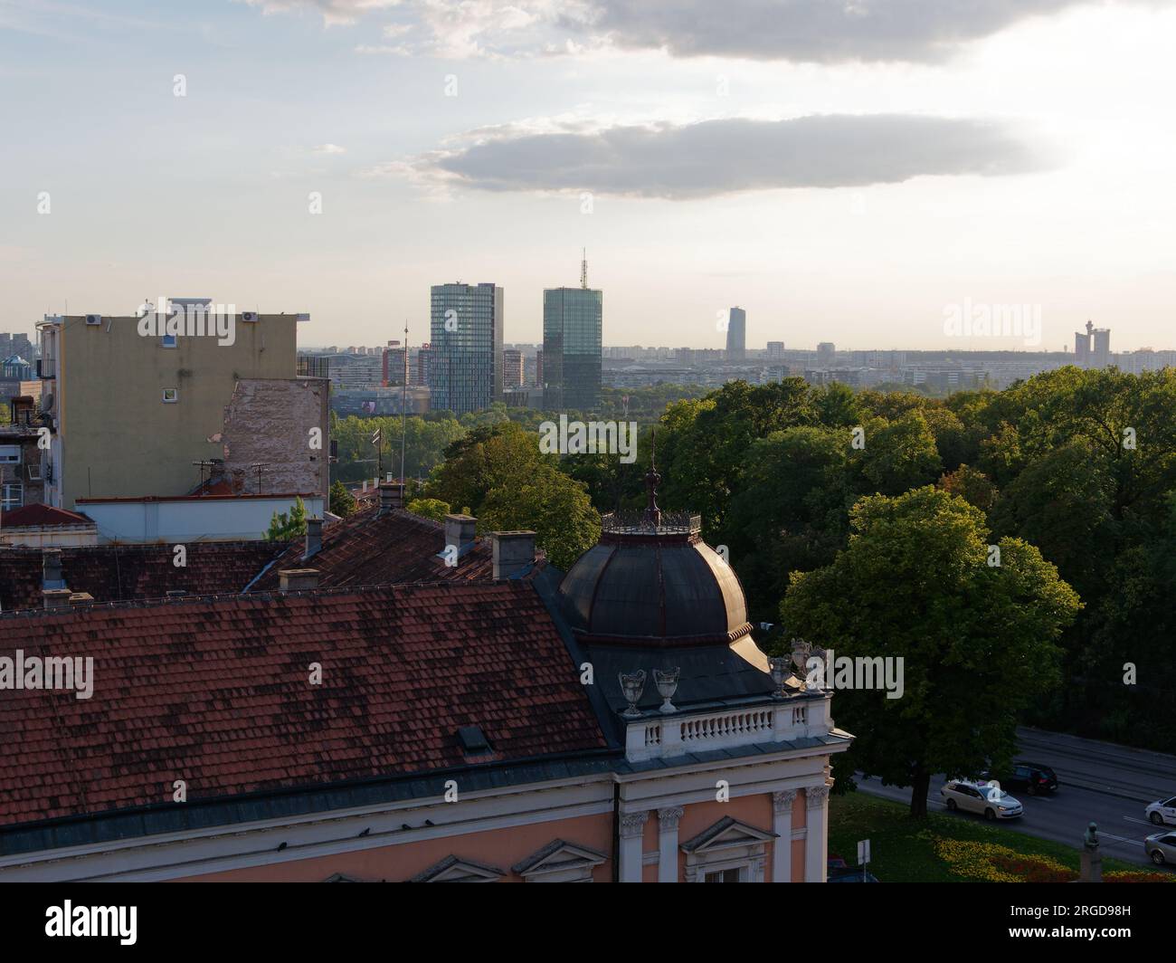Erhöhter Blick über die elegante Dachterrasse in Richtung eines Parkbereichs mit Wohnblock in Belgrad, Serbien. August 8,2023. Stockfoto