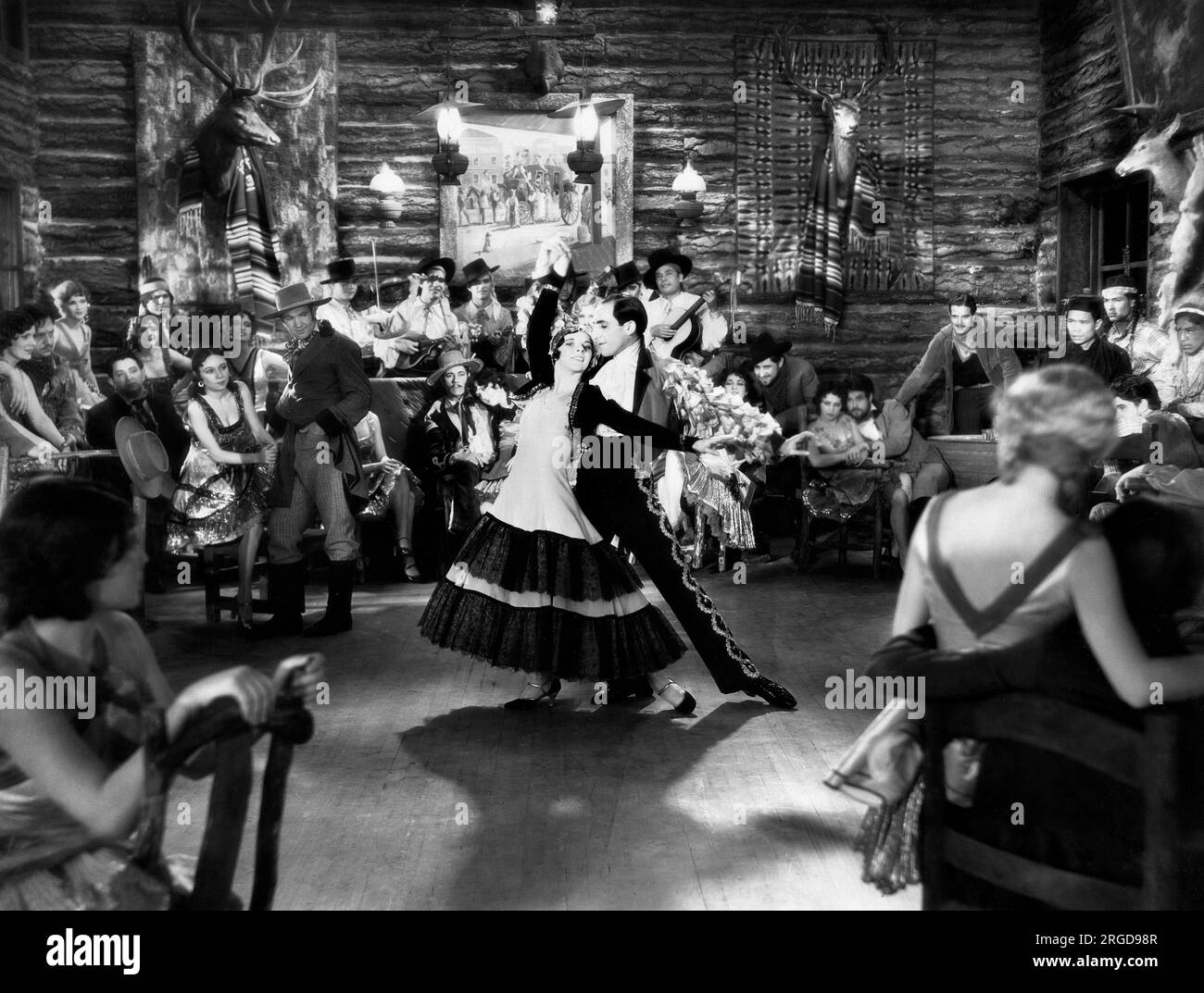 John Boles, Vivienne Segal (beide sitzen links von den Tänzern), am Filmset „Song of the West“, Warner Bros., 1930 Stockfoto