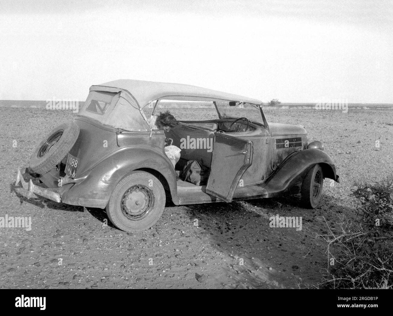 1935 Ford Model 48 Phaeton 4-türiges Cabriolet, Regn 1088, in der Wüste, irgendwo in einer Wüste im Nahen Osten. (Hinweis: Weniger als 1 % der Produktion des Modells 48 entfielen auf die „4-türige Phaeton Cabriolet“-Marke.) Stockfoto