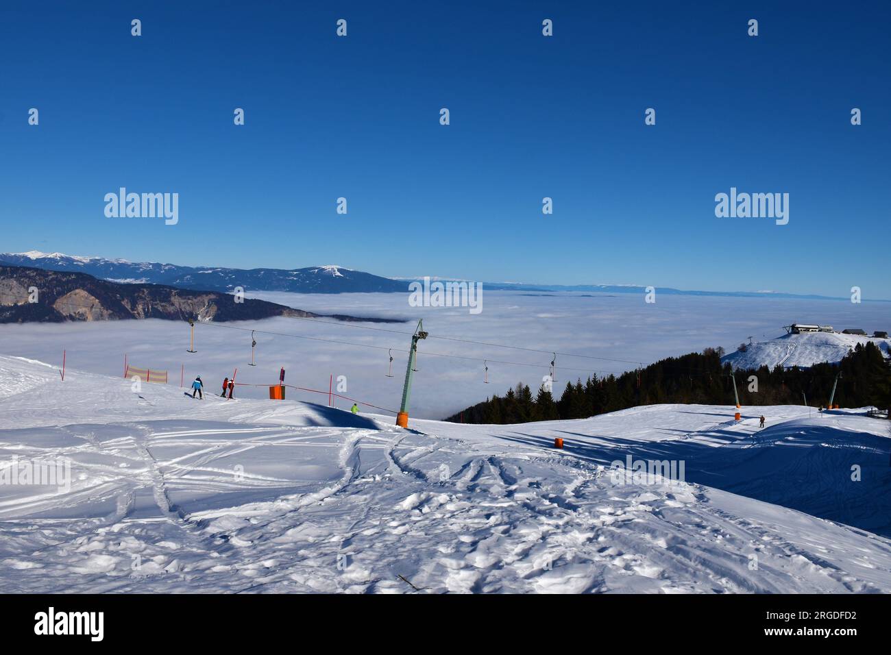Dreiländereck arnoldstein-Skipiste im Karawanks-Gebirge in Österreich und Kärnten dahinter mit Nebel bedeckt Stockfoto