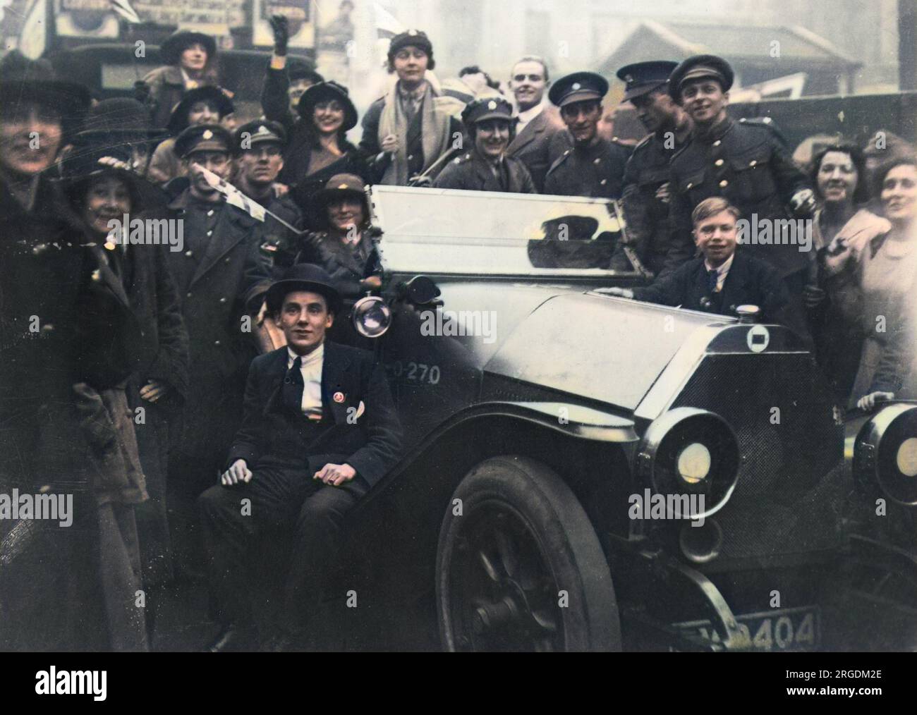 Eine glückliche Menschenmenge von Männern und Frauen, einige in Militäruniform, andere in Zivilisten, in London am Waffenstillstandstag, 11. November 1918, um ein Auto herum. Stockfoto