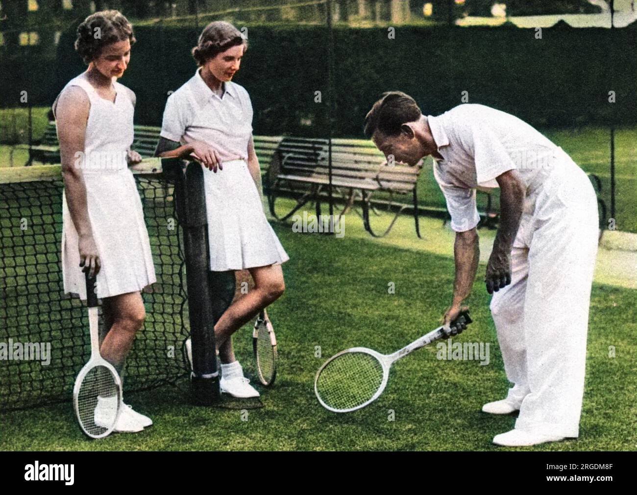 Dan Maskell (1908 - 1992), britischer Tennisspieler, Trainer und später war der Kommentator von Wimbledon allseits beliebt. Das Bild zeigt Miss Mary Hardwick und Miss Kay Stammers die richtige Methode, um eine halbe Volleyladung abzugeben. Stockfoto