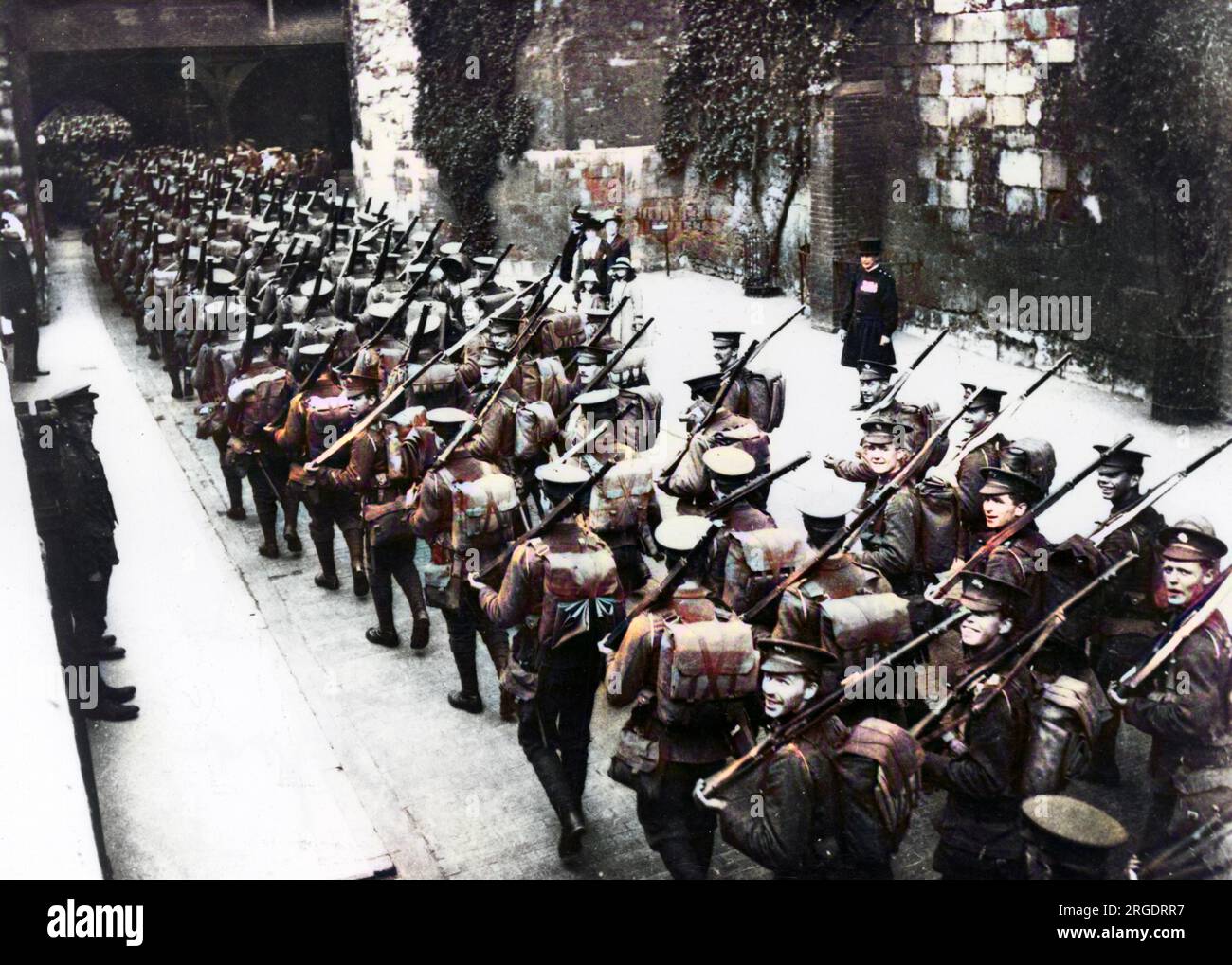 Männer der 2. Schotten Wachen verlassen den Tower of London, um in Lyndhurst im New Forest zu lagern, um die 7. Division während des Ersten Weltkriegs zu gründen. Einige von ihnen lächeln in die Kamera, und ein Feater schaut von der Seite zu. Stockfoto