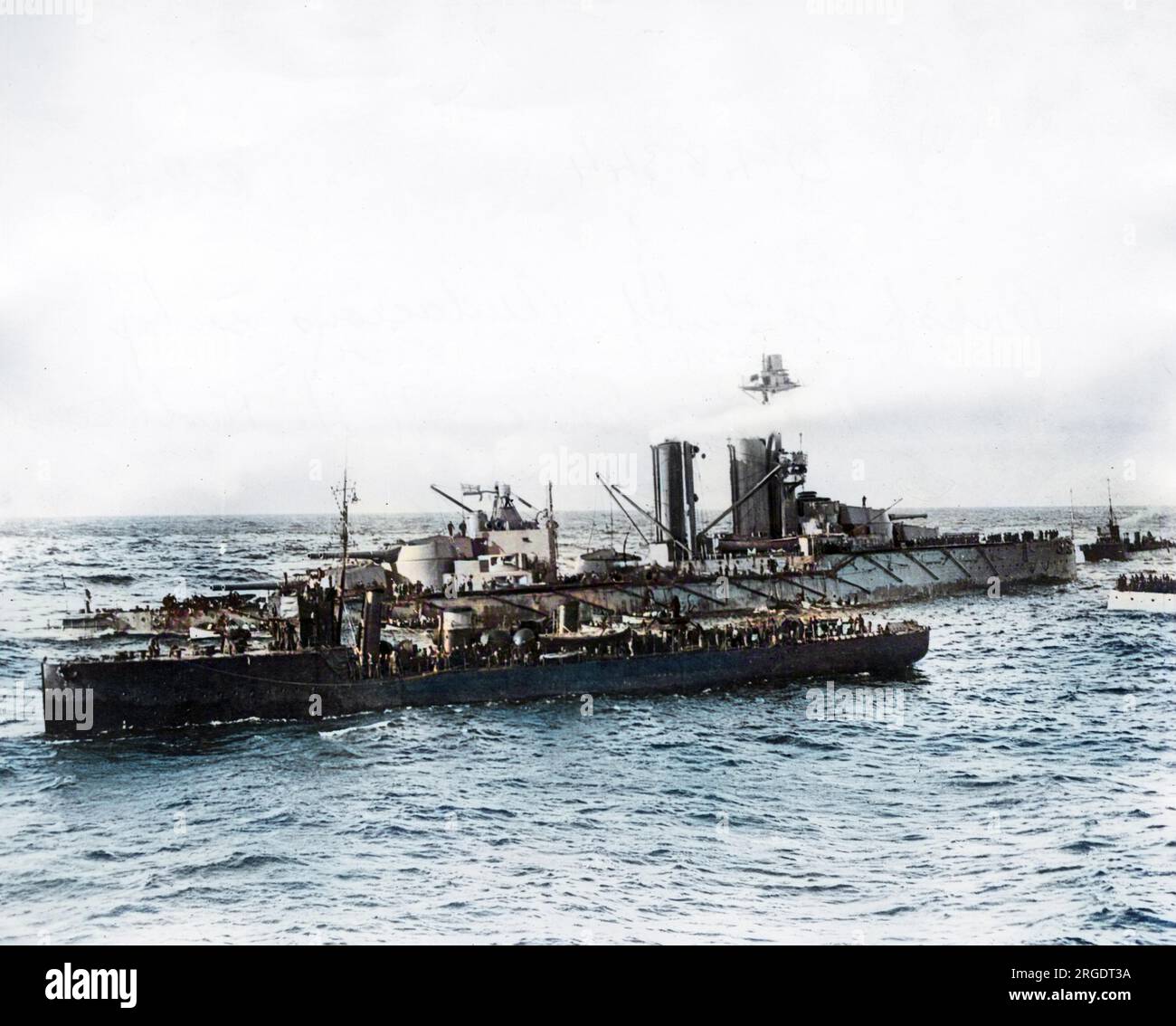 HMS Kühnheit, britisches Schlachtschiff der V-Klasse von King George, startete 1912. Während des Ersten Weltkriegs sah sie nichts, da sie von einer deutschen Mine vor der Nordküste von Donegal, Irland, versenkt wurde, wie auf diesem Foto zu sehen ist. Die Besatzung fährt zu den Rettungsbooten und andere Schiffe kommen zur Rettung. Stockfoto