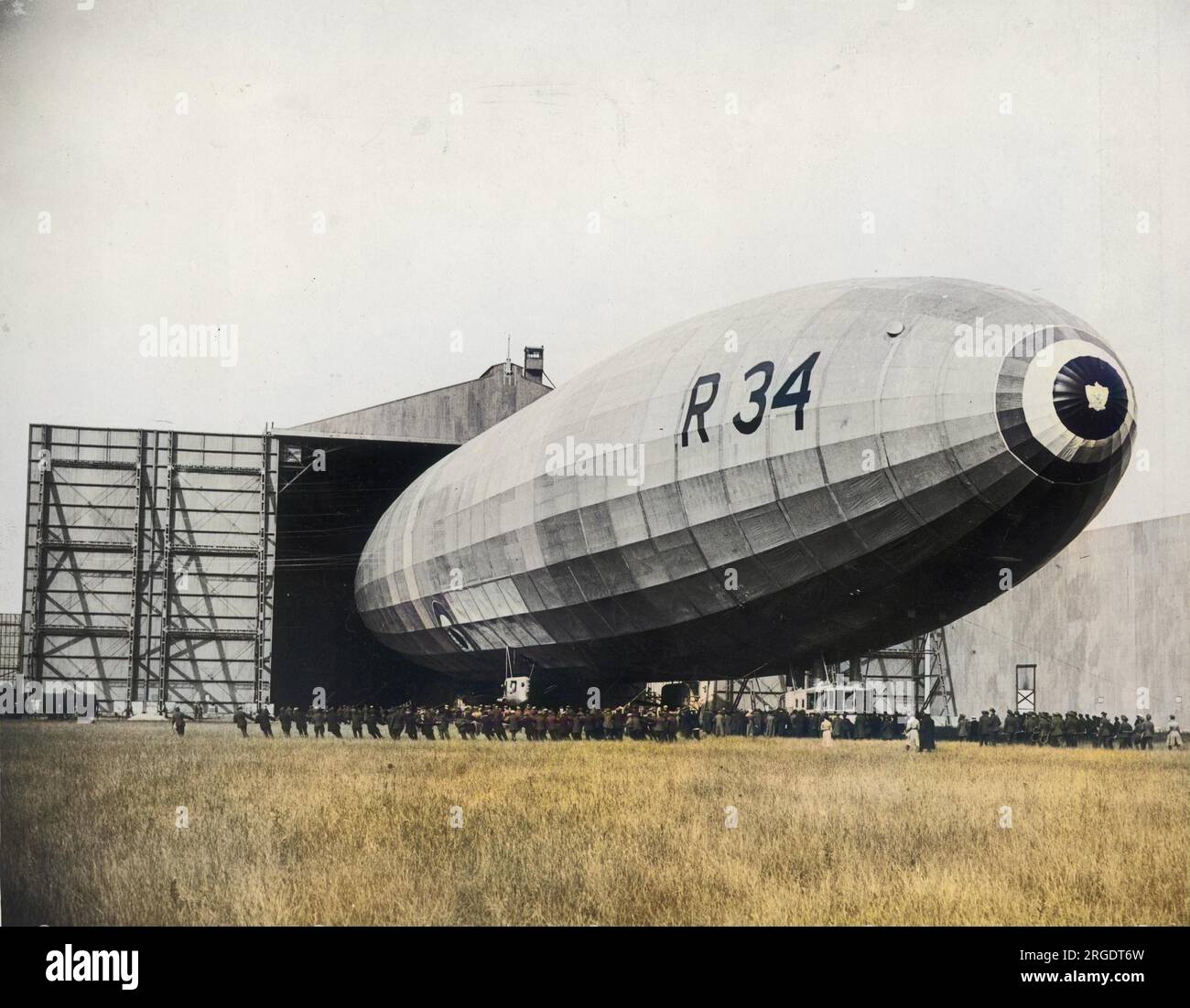 Das britische Luftschiff R34 (Klasse R33), das aus ihrem Hangar kommt. Sie war ein starres Luftschiff, das während des Ersten Weltkriegs für den Royal Naval Air Service (RNAS) gebaut wurde. Am 14. März 1919 startete sie ihren ersten Flug und war am 2-6. Juli 1919 das erste Flugzeug, das eine Ost-West-Überfahrt über den Atlantik unternahm. Stockfoto