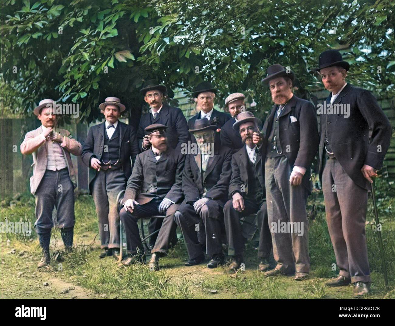 Gruppenfoto von Männern in einem Garten, einige mit Bart, andere mit Schnurrbart, die glücklich und entspannt aussehen. Stockfoto