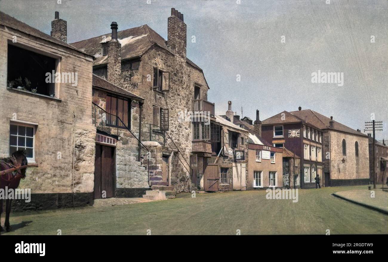 Eine Straßenszene in St. Ives, Cornwall, mit Häusern und Geschäften und einem Schild mit der Werbung für BP. Stockfoto