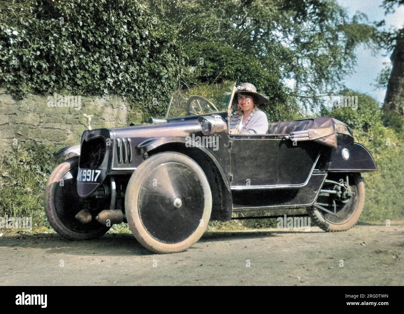 Eine lächelnde junge Frau in einem Sportwagen mit offenem Dach. Stockfoto