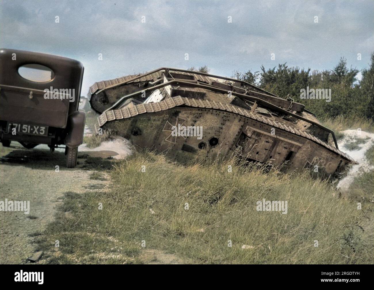 Ein deutscher Panzer aus dem 1. Weltkrieg in einem flachen Graben am Ende des Krieges, mit einem Auto, das vorbeifährt. Stockfoto