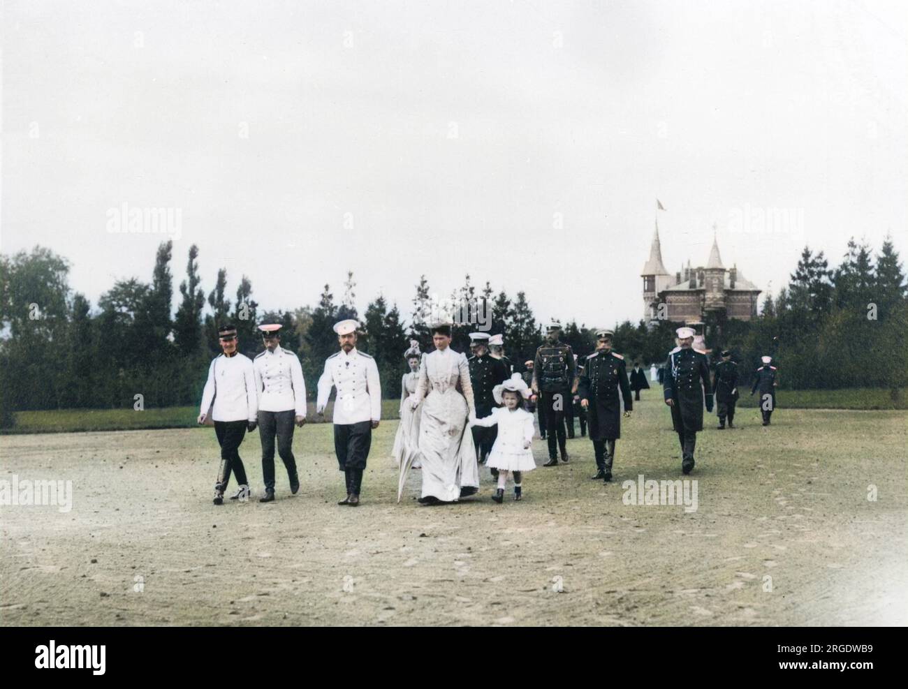 Zar Nicholas II. Von Russland spaziert durch die Landschaft von Krasnoe Selo in einem großen Gefolge, zu dem seine Frau Alexandra Feodorowna, eine seiner Töchter, andere Familienmitglieder und mehrere Beamte gehören. Stockfoto