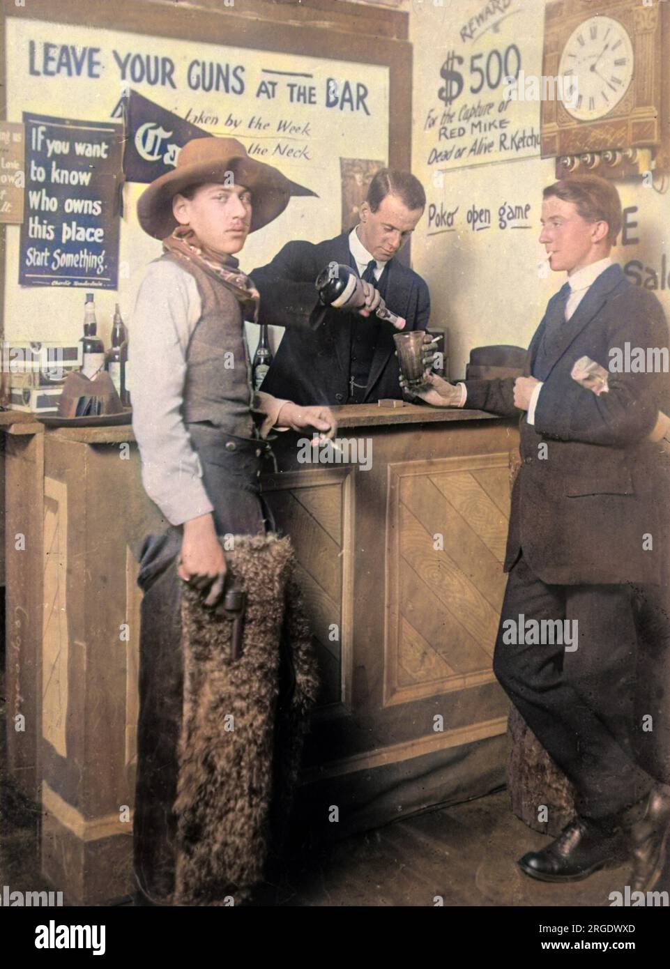 Ein Cowboy, der raucht und eine Waffe in der Bar hält. Auf dem Schild über der Bar steht: 'Lasst eure Waffen an der Bar liegen'. Stockfoto