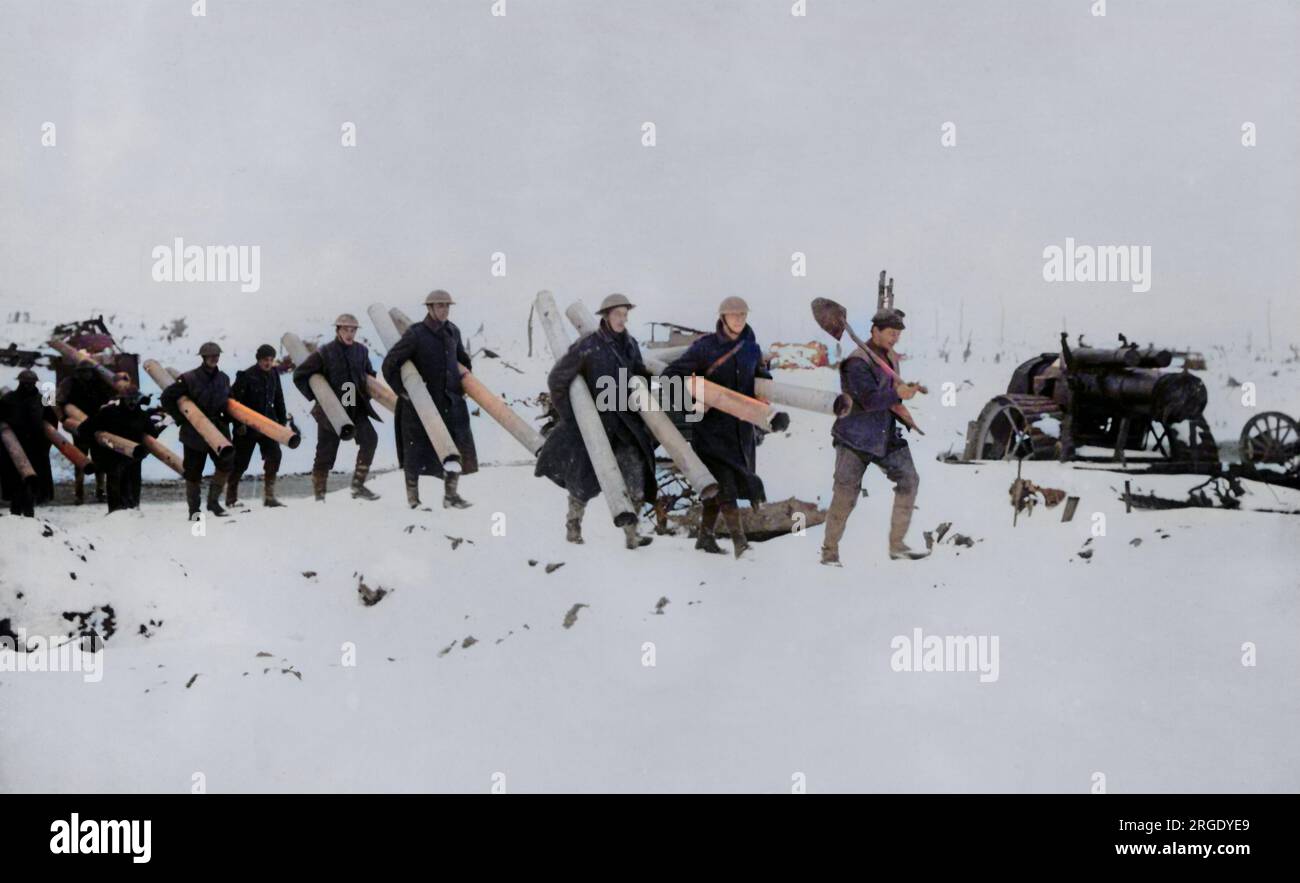 Eine britische Arbeitsgruppe im Schnee an der Westfront während des Ersten Weltkriegs, mit Ofenrohren, mit einer großen Waffe in der Nähe. Stockfoto
