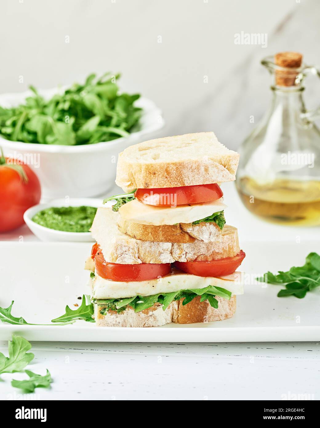Gestapeltes Vegan Caprese Sandwich auf einem weißen Teller Stockfoto