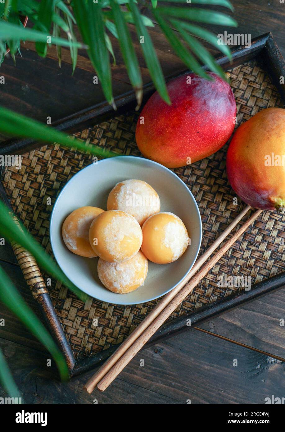japanische Mango-Mochi-Kuchen mit Eiscreme auf einem klassischen asiatischen Holztablett Stockfoto