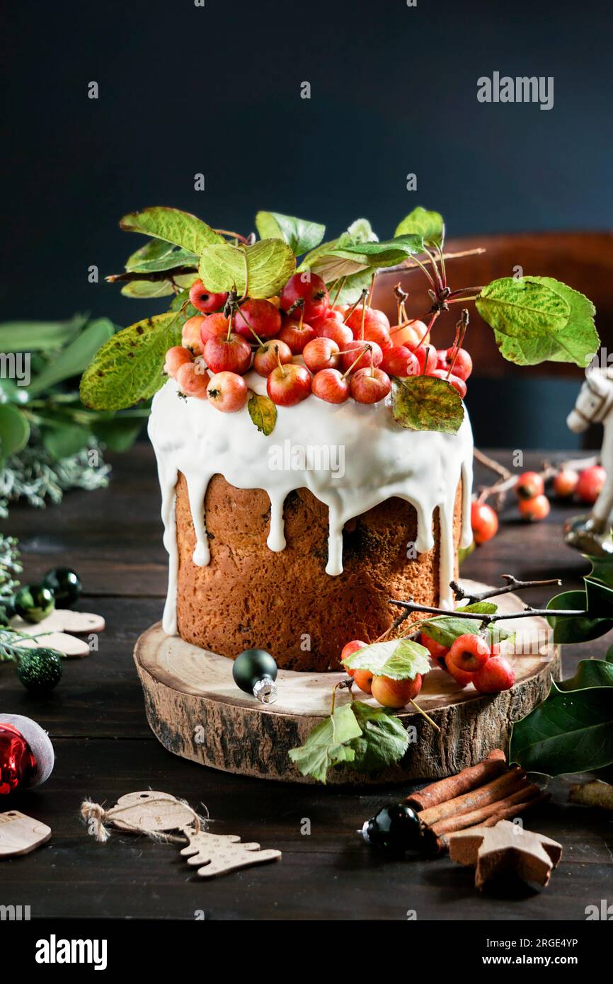 Weihnachts-Neujahrskuchen mit Glasur und glasierten Früchten und Beeren. Dunkler Holzhintergrund, Urlaubskonzept. Weihnachtsgruß c Stockfoto