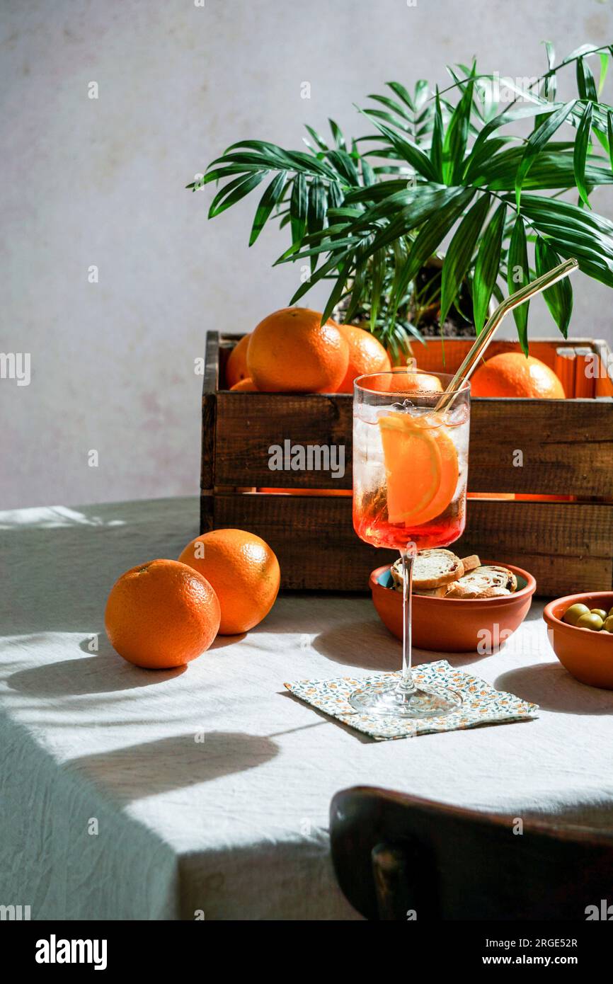 aperol Spritz, Cocktail, auf Leinentischdecken, Schatten, hartes Sonnenlicht, Sommergetränk im Glas Stockfoto
