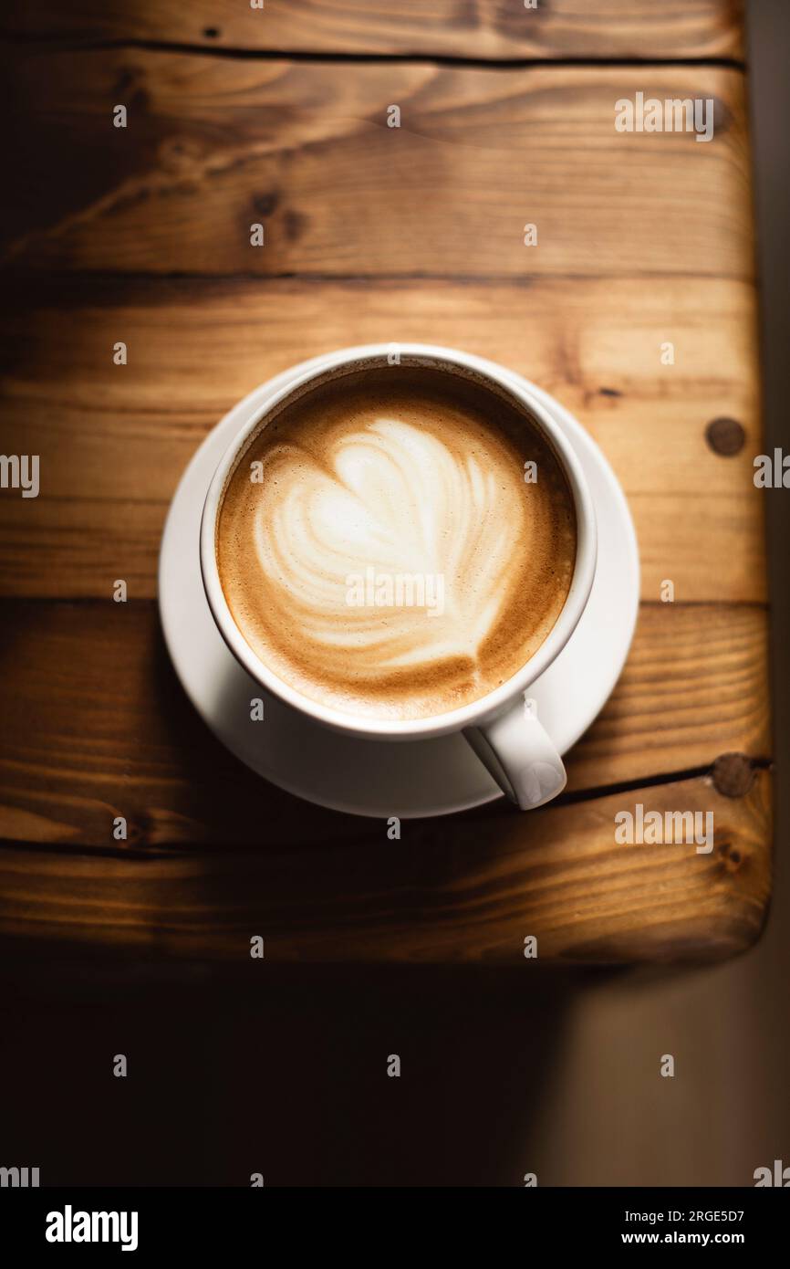 Kaffee in weißer Tasse auf Holztisch, mit Löffel. Stockfoto