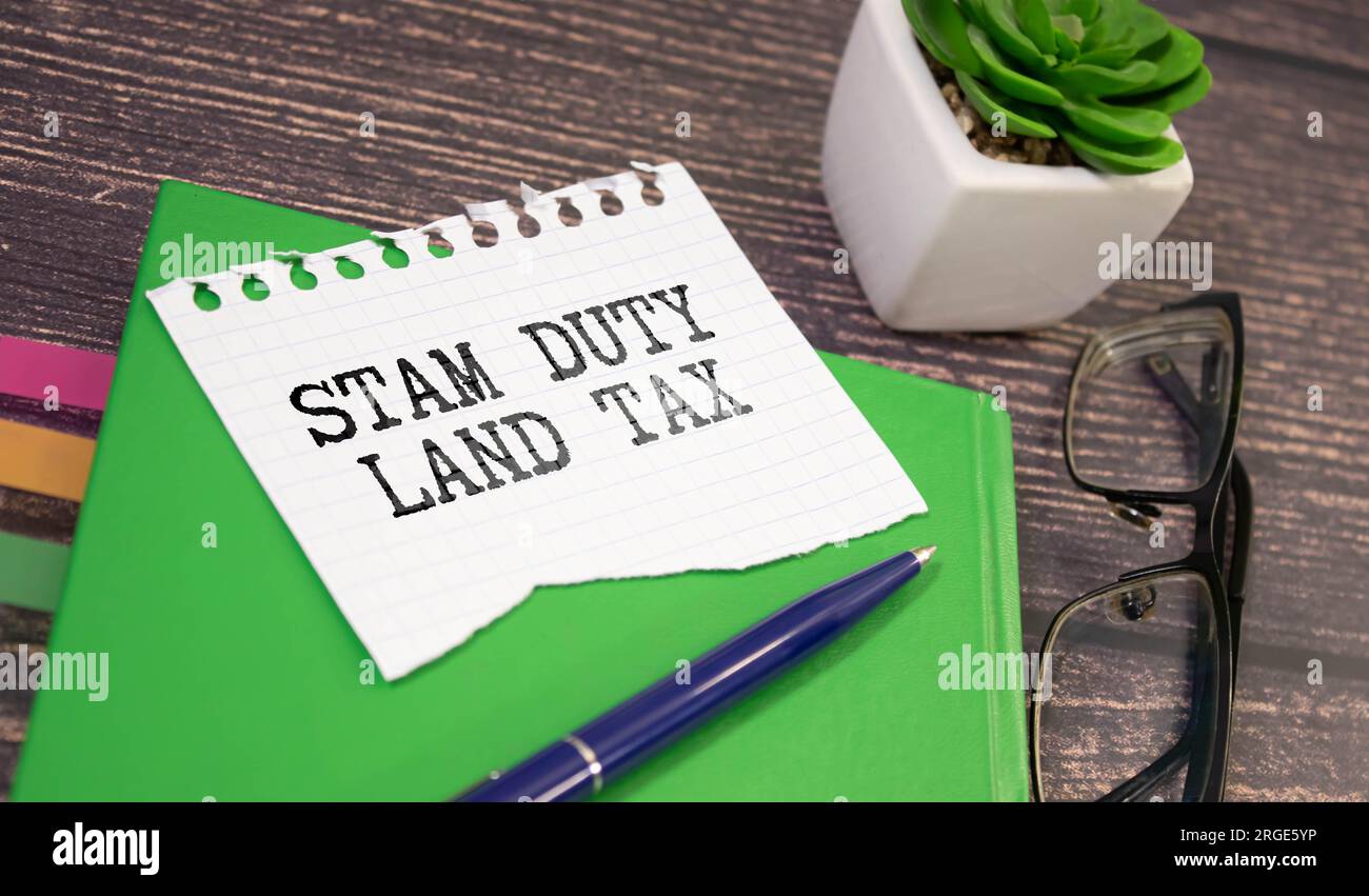 SDLT – Stempelgebühr für Grundsteuer ist auf einem Notizbuch auf gelbem Hintergrund vermerkt Stockfoto