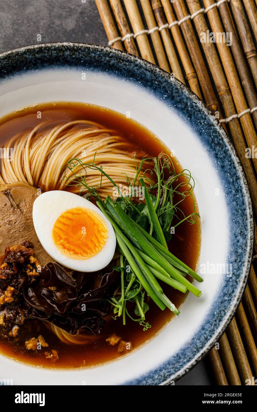 Ramen-asiatische Nudeln in Brühe mit Rinderzungenfleisch, Pilz und Ei in der Schüssel Stockfoto