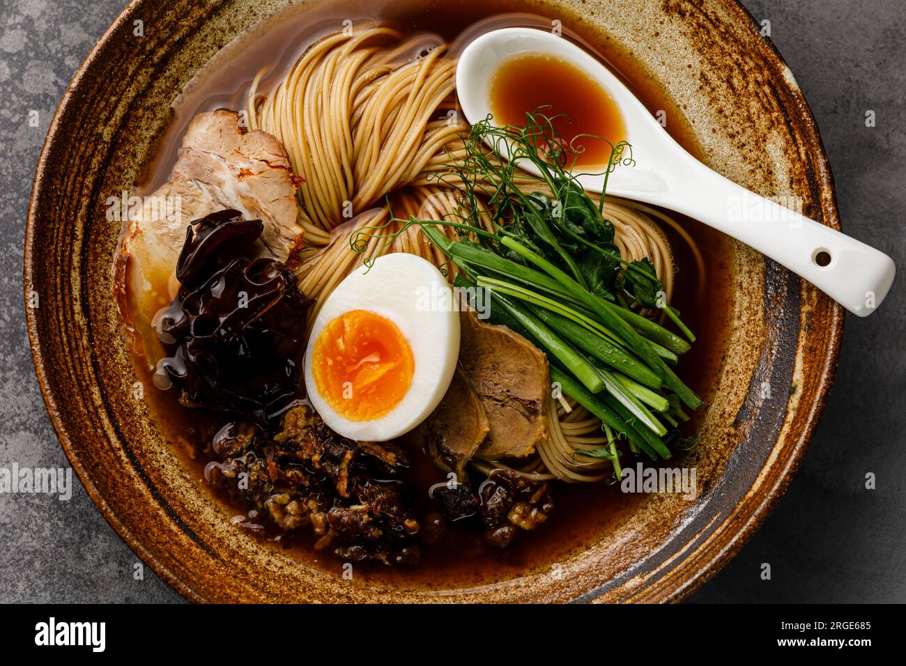 Ramen-asiatische Nudeln in Brühe mit Rinderzungenfleisch, Pilz und Ei in der Schüssel Stockfoto
