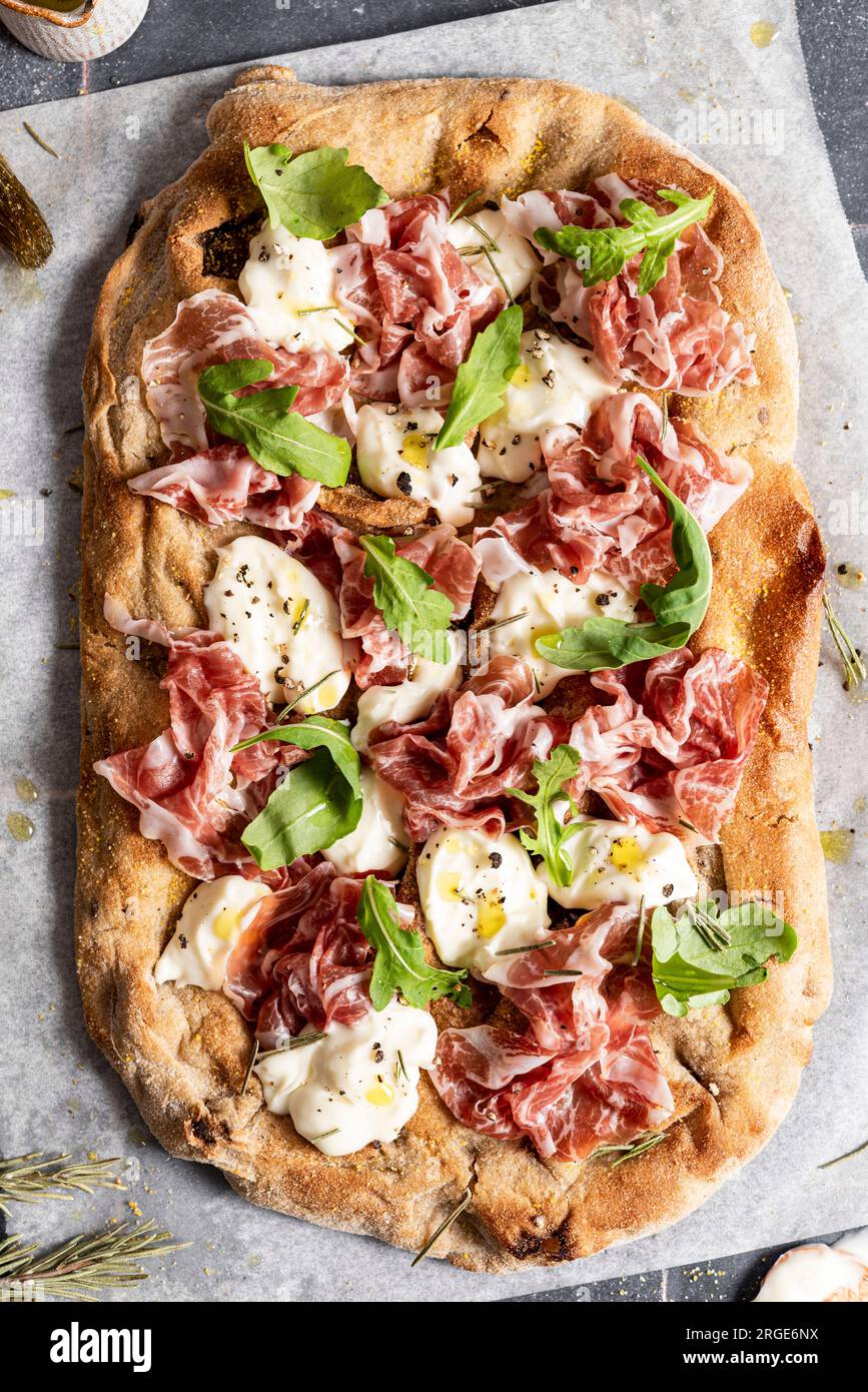 Pizza mit Prosciutto, Käse und Raketenblättern Stockfoto