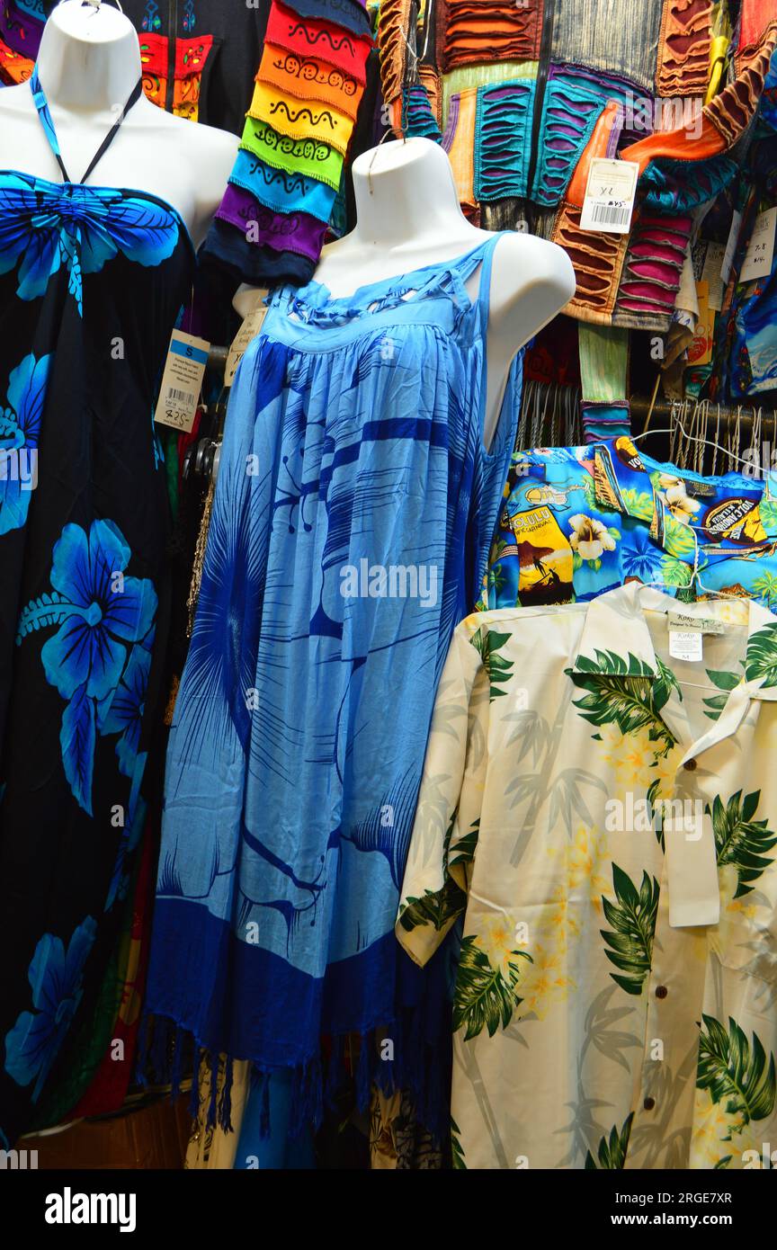 Auf einem Markt in der Nähe von Waikiki Beach werden hawaiianische Oldtimer-Hemden und -Kleider verkauft, auf denen Touristen tropische Mode kaufen können Stockfoto