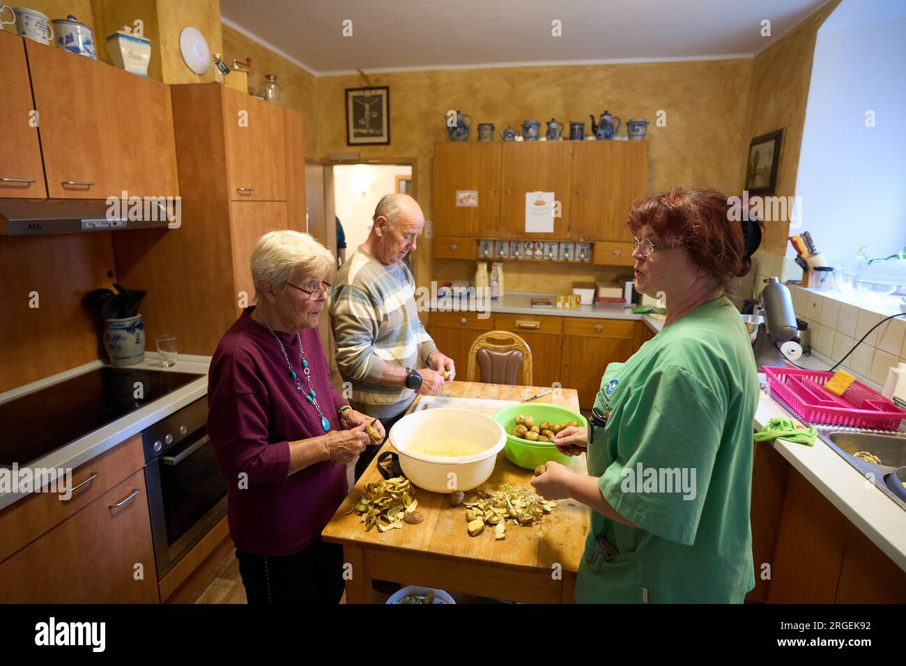 Marienrachdorf, Deutschland. 08. Aug. 2023. Die Bewohner der Pflegefarm bereiten das Mittagessen zusammen zu. Auf dem Bauernhof sollen die Menschen am Alltag teilhaben. Auf einem Bauernhof in der Nähe von Koblenz bilden pflegebedürftige Senioren eine Wohngemeinschaft mit Alpakas, Rindern und Schweinen. Das ungewöhnliche Konzept wird gut aufgenommen. Kredit: Thomas Frey/dpa/Alamy Live News Stockfoto