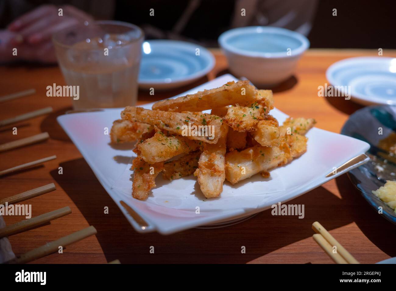 Frittierte japanische Süßkartoffeln, serviert mit einer Kühlbox. Abendessen am späten Abend in Japan. Stockfoto