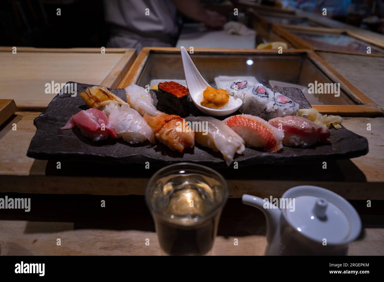 Sushi-Platte, eine Auswahl an rohem Fisch und Reissnacks mit Stäbchen. Stockfoto