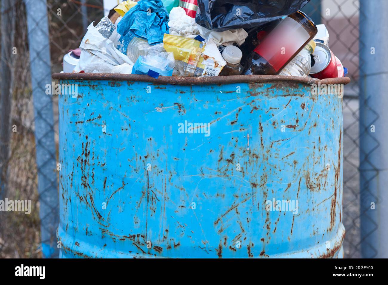 Rostige Mülltonne voller Müll. Papierkorb-Management. Umweltproblem Stockfoto